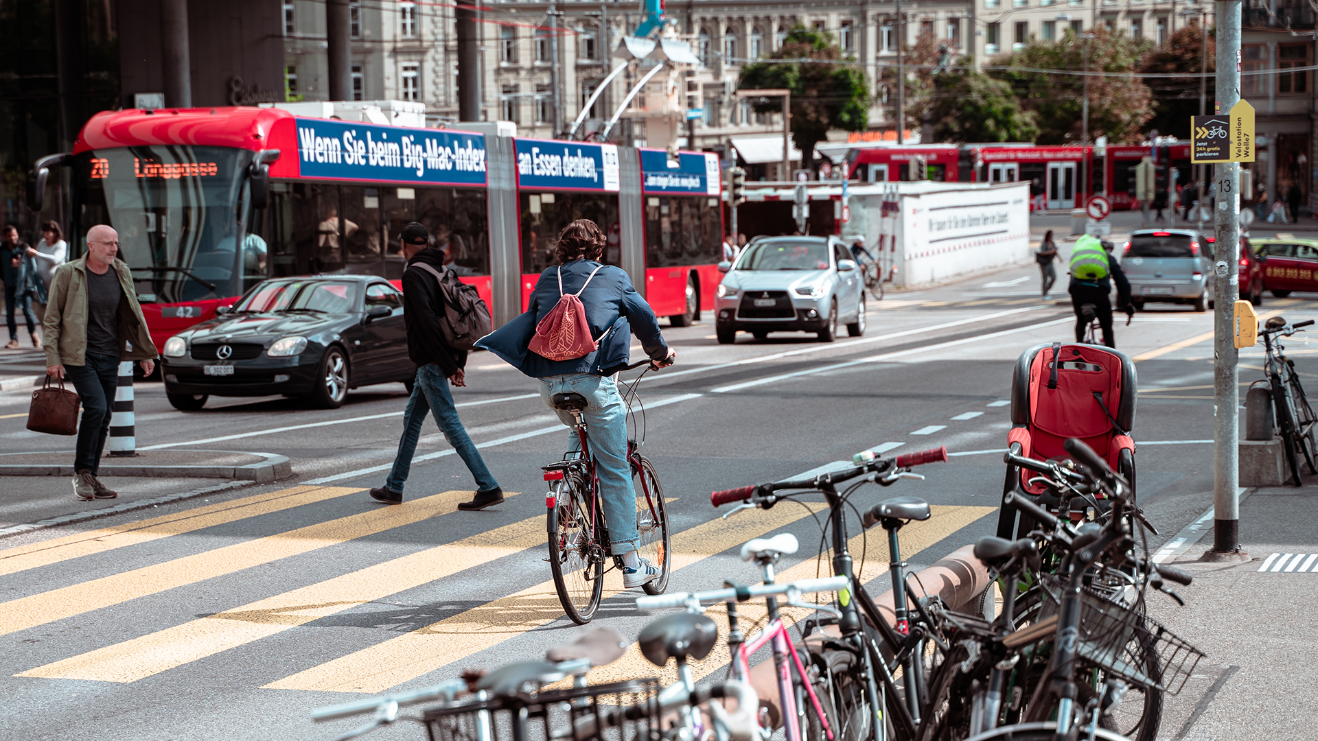 Velo-Fahrer auf den Strassen von Bern fährt neben BERNMOBIL Bus durch