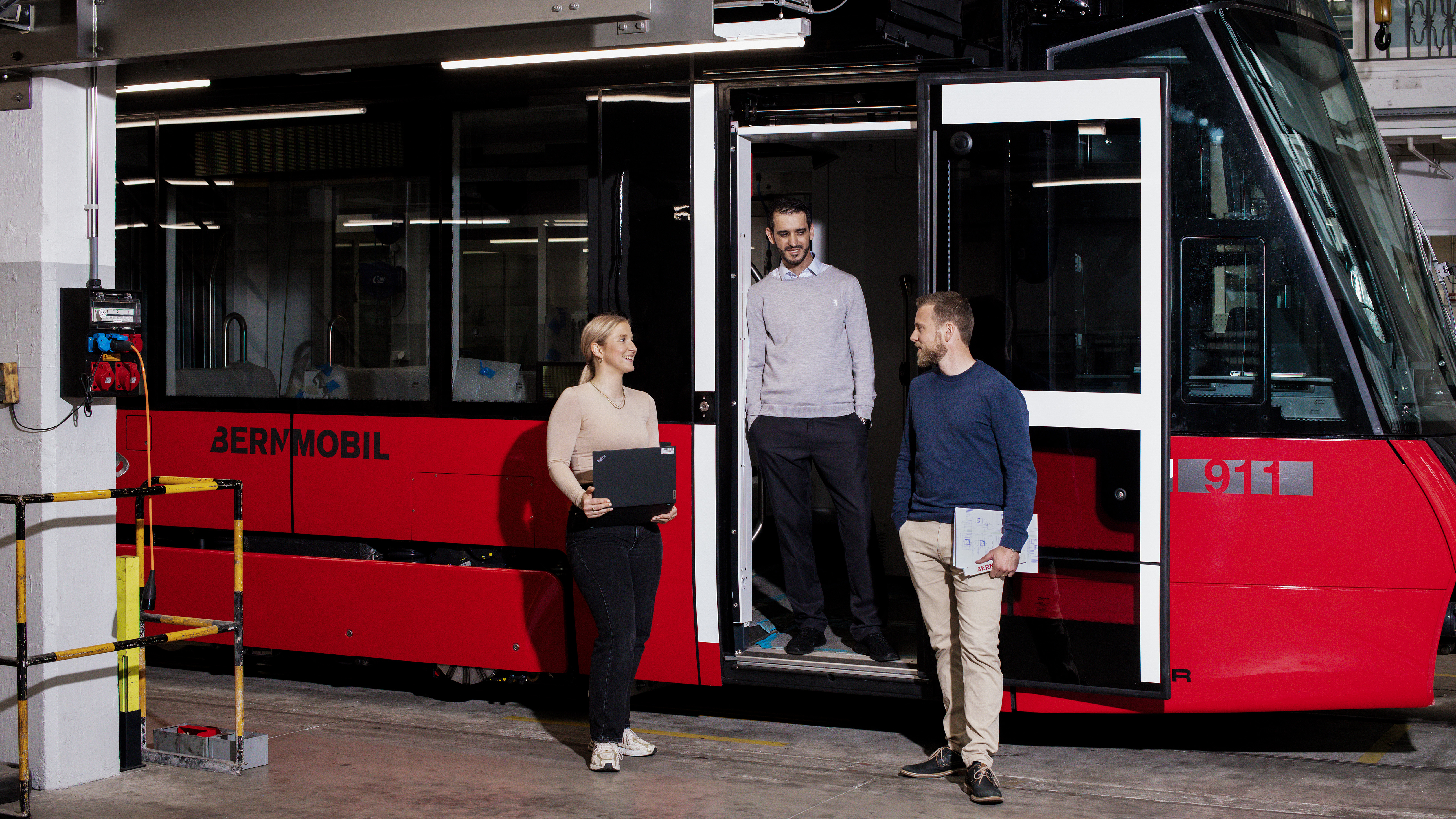 Mitarbeitende vor einem Tram bei der Arbeit